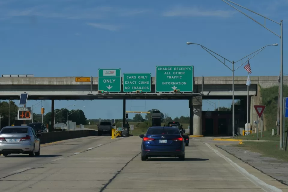 View of cars on Oklahoma road with green signs signaling tolls ahead